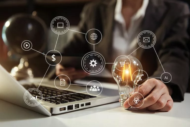 business hand hÃÂält glÃÂühbirne mit laptop computer und geld stapel im bÃÂüro. idee energie sparen und buchhaltung finanzkonzept
