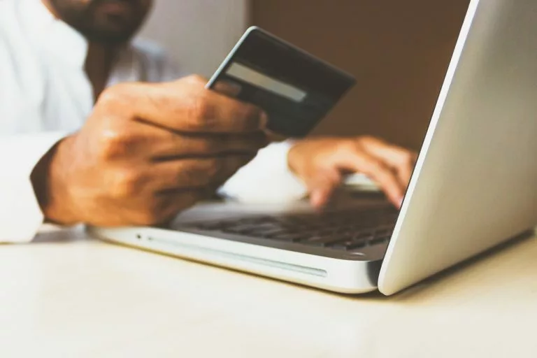 Eine Person sitzt am Laptop und bereitet sich darauf vor, etwas online zu bezahlen. In unserem Artikel vergleichen wir beliebte Zahlungsanbieter und präsentieren Ihnen die besten Zahlungsanbieter im Jahr 2024.