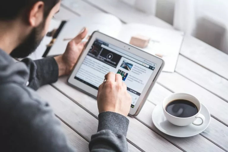 eine Person arbeitet an einem Tablet. In unserem Artikel zeigen wir Dir alles Ã¼ber das Einrichten eines Blogs mit IONOS.