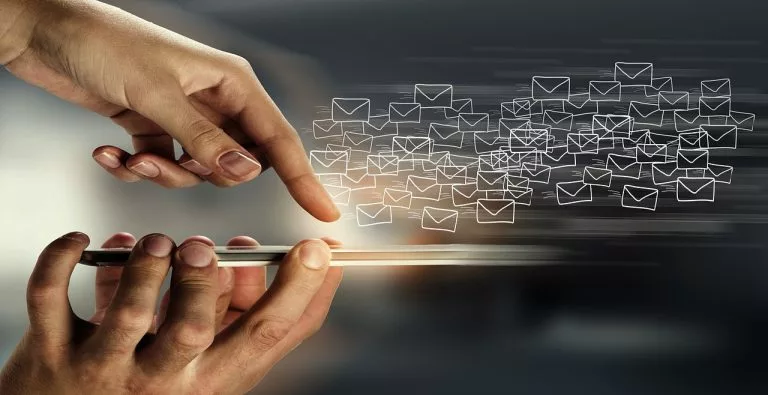Eine Hand klickt auf ein Telefon, um eine E-Mail zu senden. In unserem Artikel bringen wir Dir alles über E-Mail-Strategien bei.