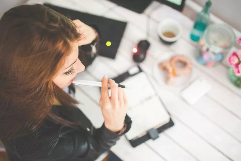 logo erstellen kostenlos, kreativität bei der Arbeit, Frau mit dem Notizen und Stift denkt