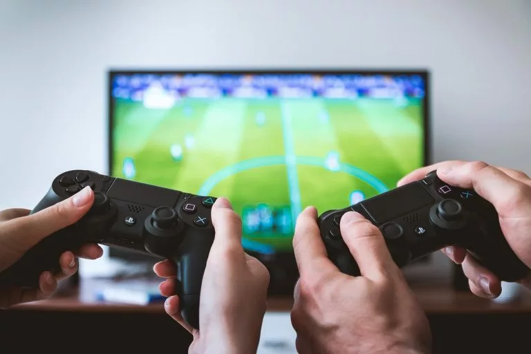 Zwei Personen spielen ein Videospiel vor einem Fernseher.