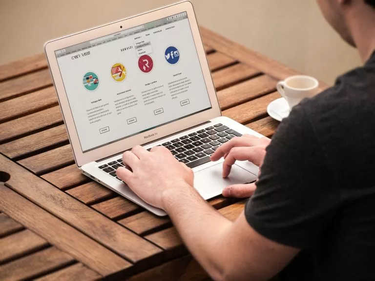 Ein Mann arbeitet an einem Laptop. Hier findest Du alles über die Recherche des Wettbewerbs für Logoideen.