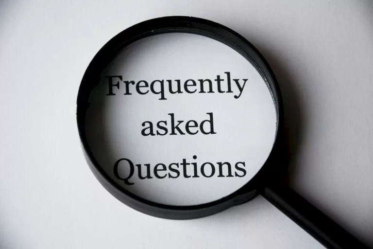 ein VergröÃerungsglas zeigt häufig gestellte Fragen an (frequently asked questions).